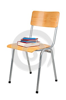 Books on school chair isolated on white