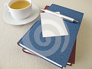 Books, sheet of paper and tea