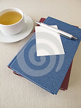 Books, sheet of paper and tea