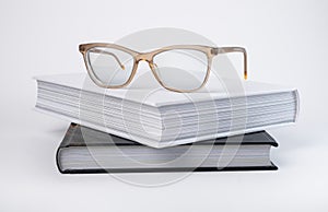 Books stack with eyeglasses. Encyclopedia, bible, code or novel on grey background. Reading and getting knowledge