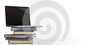 Books stack and a laptop on white background