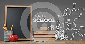 Books on the table against grey blackboard with education and school graphics