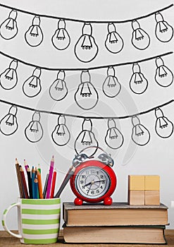 Books on the table against white blackboard with bulb graphics