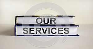 Books with text `our services` on beautiful white background. Business concept. Copy space
