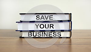 Books with text `save your business` on beautiful wooden table. White background. Business concept