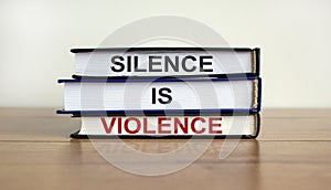 Books with text `silence is violence` on beautiful wooden table. White background. Business concept