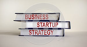 Books with text `strategy startup business` on beautiful white background. Business concept. Copy space