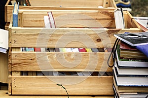 Books in a wooden box are prepared for sale at a street fair