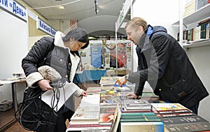 Bookseller standing behind a bookstore counter and telling about books available