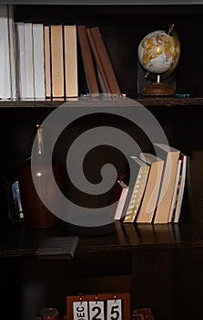 Bookshelf with books, globe, and decoration for a cozy reading corner ambiance photo