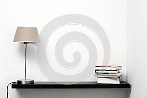 Bookshelf on the wall with lamp and books photo