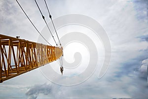 about the boom hoisting of crane at construction site and blue sky by emphasizing at boom crane detail and sling