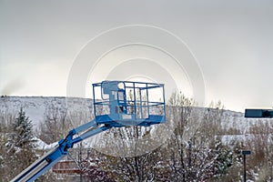 Boom lift against mountain and sky in winter