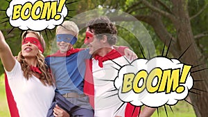 Boom text on speech bubbles against mother and dad carrying their son in superhero costume