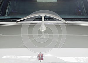 Boomerang shaped spoiler on white classic Lincoln car in landscape