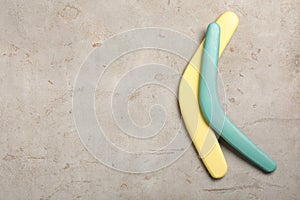 Boomerangs on light grey stone background, flat lay. Space for text