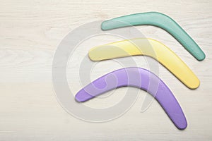 Boomerangs on white wooden background, flat lay. Space for text