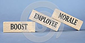 BOOST EMPLOYEE MORALE - words on wooden blocks on blue background photo