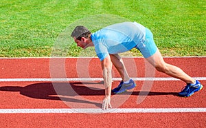 Boost speed concept. Man athlete runner push off starting position stadium path sunny day. Runner captured in motion