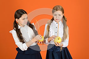 Boost student acceptance of fruit. Distributing free fresh fruit at school. Girls kids school uniform orange background