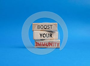 Boost your immunity symbol. Concept word Boost your immunity on wooden blocks. Beautiful blue background. Helthcare and Boost your photo