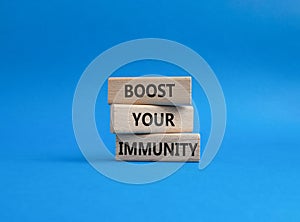 Boost your immunity symbol. Concept word Boost your immunity on wooden blocks. Beautiful blue background. Helthcare and Boost your photo