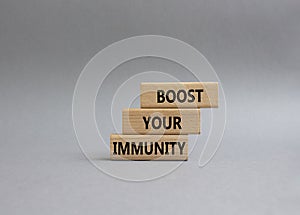 Boost your immunity symbol. Concept word Boost your immunity on wooden blocks. Beautiful grey background. Helthcare and Boost your photo