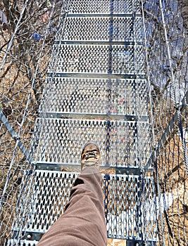 boot of man on the suspension bridge