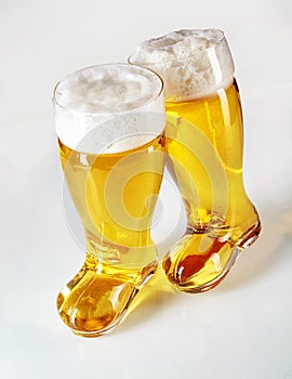 Boot shaped beer glasses filled with frothy lager