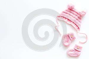 Booties and hat for newborn girl on white background top view mockup