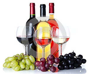 Bootles and glasses of wine with black, red and white grapes