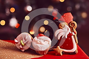 Boots filled of treats. Saint Nicholas cookies and cupcakes on bokeh background. Traditional holiday in Europe. Copy