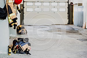 Boots and fireman`s jacket on the garage floor of a fire station