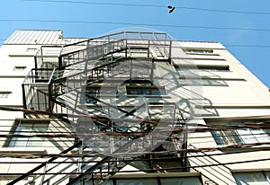 Boots hanging on a cable near white building with metal fierstairs. Vancouver`s back alley, BC, Canada