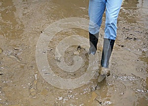 Boots in the mud of the flood after natural disaster