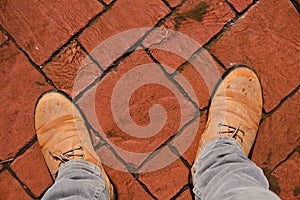 In boots on red cobblestones flooded with thawed spring water