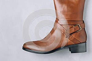 Boots. Women's brown leather high long boots on gray background. Top view
