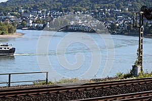 Boppard, Germany - 03 21 2020: Middle Rhine Railroad with a ship passing near Boppard