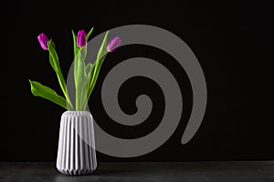 boquet of tulip on a black background standing in vase