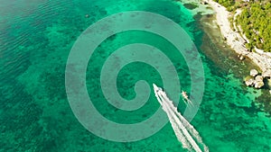 Boracay island with white sandy beach, Speed boat in the blue lagoon near the tropical beach.