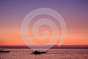 Boracay, Philippines, Jan 27, 2020: Traditional boats with tourists on the sea against the background of the setting sun