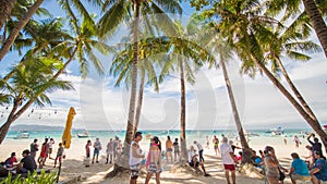 BORACAY, PHILIPPINES - JANUARY 7, 2018 - Tourists relaxing on the paradise shore of the White Beach in Boracay