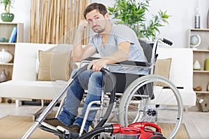 borde disabled man in wheelchair uses vacuum cleaner photo