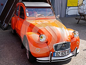 Citroen 2CV sign and brand logo front of retro orange vintage french historical car