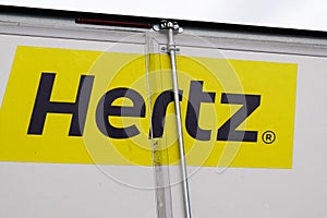 Hertz logo brand and text sign of American car rental company on rear truck panel van