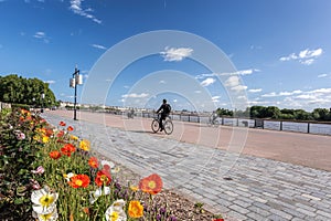 Bordeaux with cyclist on spring promenade along Garonne river in France