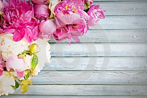 Border of Beautiful pink and white peony flowers on wooden table with copy space for your text top view and flat lay