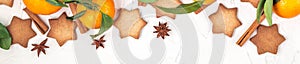 Border of Christmas star cookies with spices and mandarin on white background with copyspace