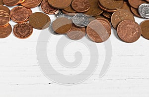 Border of coins on a white table, money savings concept with copy space