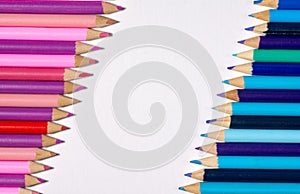 Border / edge of colored pencils with blue/purple on one side and pink/purple on the opposite with white space in-between.